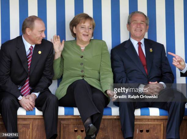 Russian President Vladimir Putin, German Chancellor Angela Merkel and U.S. President George W. Bush joke as they sit in a beach chair during the...