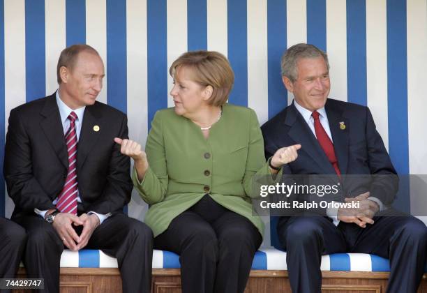 Russian President Vladimir Putin, German Chancellor Angela Merkel and U.S. President George W. Bush chat as they sit in a beach chair during the...