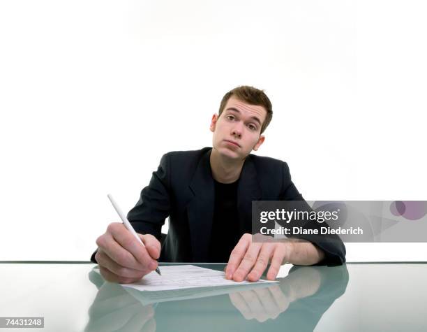 a young man filling out an employment application - diane diederich fotografías e imágenes de stock