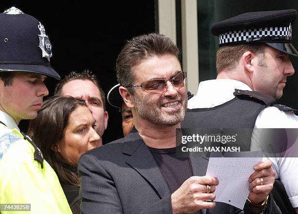London, UNITED KINGDOM: British singer George Michael reads a statement as he leaves the Brent Magistrates Court in London, 08 June 2007, after...