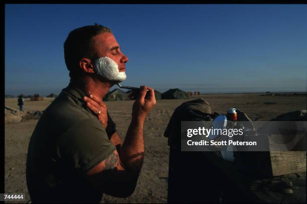 Marine shaves December 20, 1996 in Udairi Range, Kuwait. The US launched a month-long military exercise and marines moved directly to their operation...