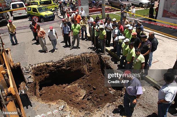 Personal de la Municipalidad de Guatemala trabaja en un agujero que se formo tras producirse un socavon de 10 metros de diametro a raiz del colapso...