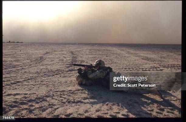 Marine lies in a combat position during a drill December 20, 1996 in Kuwait. As part of the Defense Cooperation Agreement signed by the two nations,...