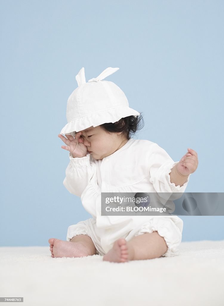 Japanese baby yawning with sitting on floor