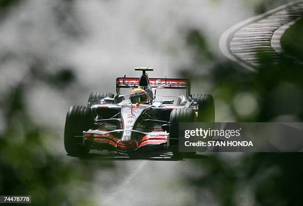 McLaren Mercedes driver Lewis Hamilton of Britain as seen through trees on the back stretch during practice 09 June 2007 at the Formula One Grand...