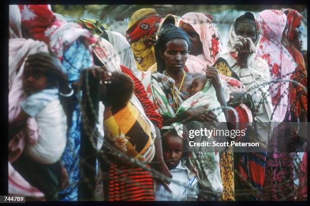 Women and children stand in line at a food distribution site June 20, 1993 in Mogadishu, Somalia. An estimated 350,000 Somalis died due to war,...