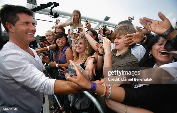 Simon Cowell acknowledges the crowd as he arrives during the first day of auditions for X Factor, Series 4 at Arsenal Emirates Stadium on June 9,...