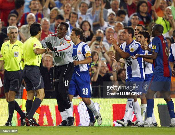 Espanyol players protest against the referee's decision to allow a goal by Barcelona's Lionel Messi which was a hand ball during a Spanish league...