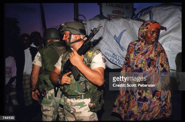 United Nations soldier stands next to a Somali woman June 6, 1993 in Mogadishu, Somalia. UN troops seized the residence of General Mohammad Aidid, a...