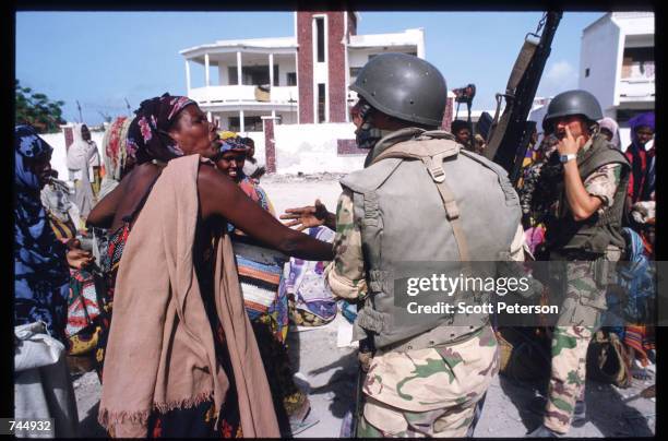 United Nations soldier speaks with a Somali woman June 6, 1993 in Mogadishu, Somalia. UN troops seized the residence of General Mohammad Aidid, a...