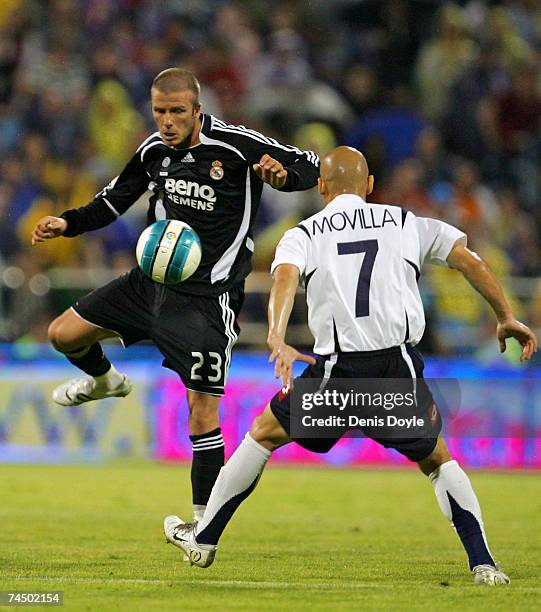 David Beckham of Real Madrid is tackled by Movilla in the Primera Liga match between Real Zaragoza and Real Madrid at the Romareda stadium on June 9,...