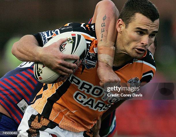 Daniel Fitzhenry of the Tigers is tackled by Knights defence during the round 13 NRL match between the Newcastle Knights and the Wests Tigers at...