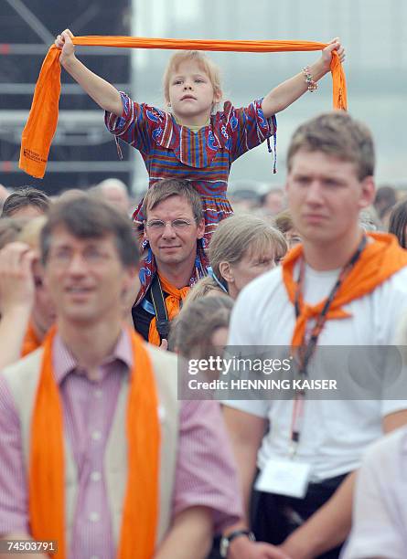 Young participant of the final open-air mass service on the last day of the 31st German Protestant Church Day waves her orange scarf 10 June 2007 in...