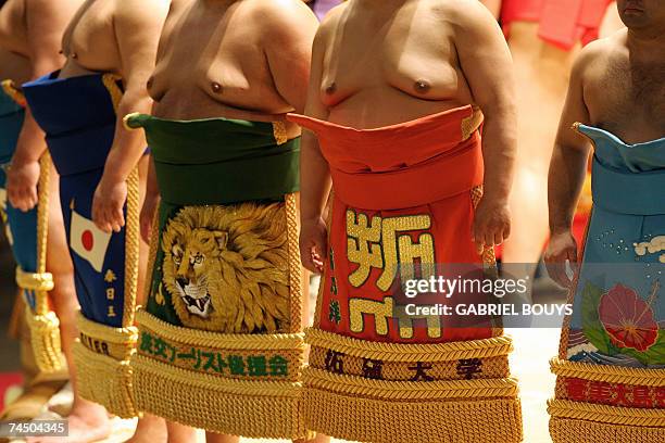 Honolulu, UNITED STATES: Sumo wrestlers display their "keiko-mawashi", ceremonial sumo aprons, during a traditional ceremony before the start of...