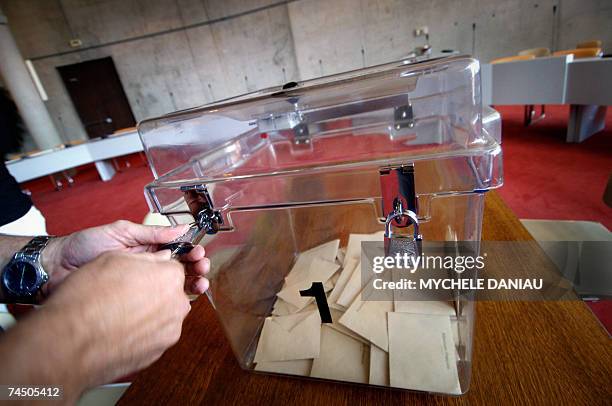 Herouville-Saint-Clair, FRANCE: A scrutineer unlocks a ballot box to count the votes at a Herouville-Saint-Clair's polling station, 10 June 2007,...