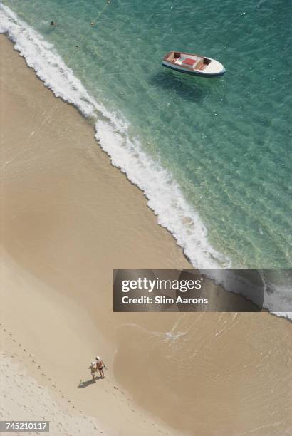 Couple walk on Caleta Beach holding hands, Acapulco, Mexico, 1968.