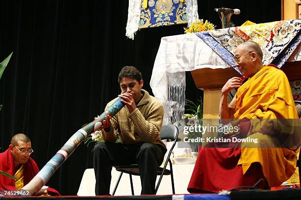 The Dalai Lama looks on as an Indegenous Australian plays the digieridoo instrument during his Buddhist blessing - White Tara Long Life Empowerment...