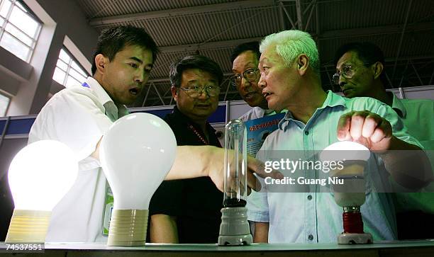 Visitors look at an energy saving light bulb during the '2007 Beijing international energy conservation and environment protection exhibition' at the...