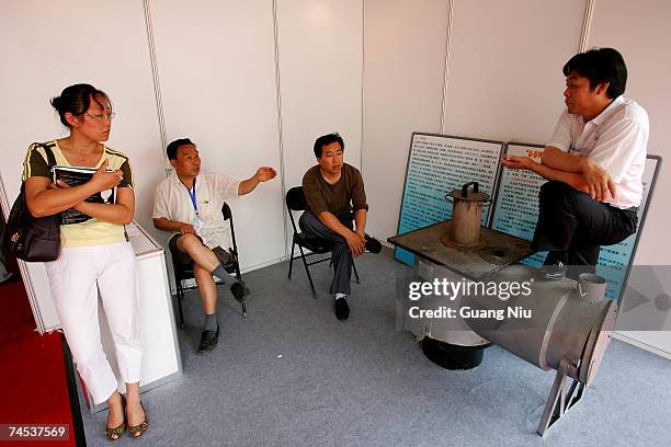 Vendor introduces his energy saving product during the '2007 Beijing international energy conservation and environment protection exhibition' at the...