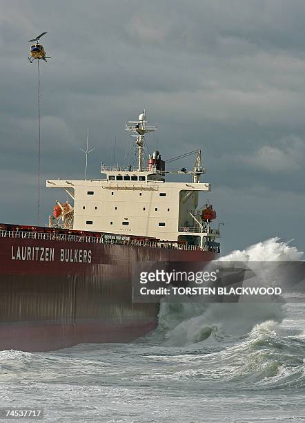 Helicopter lowers salvage equipment to the deck of the 30,000-tonne bulk coal carrier 'Pasha Bulker' which ran aground in wild seas off Nobbys Beach...