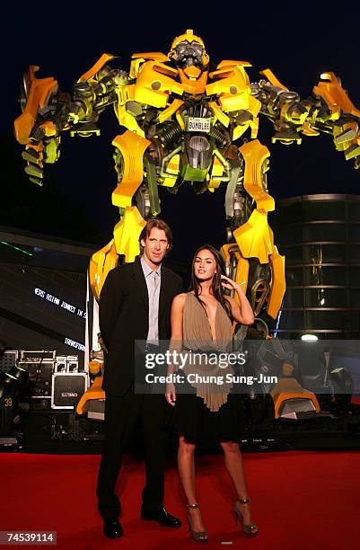 Film director Michael Bay and actress Megan Fox attend in front of Bumble Bee before a press conference to promote their new film "Transformers" on...