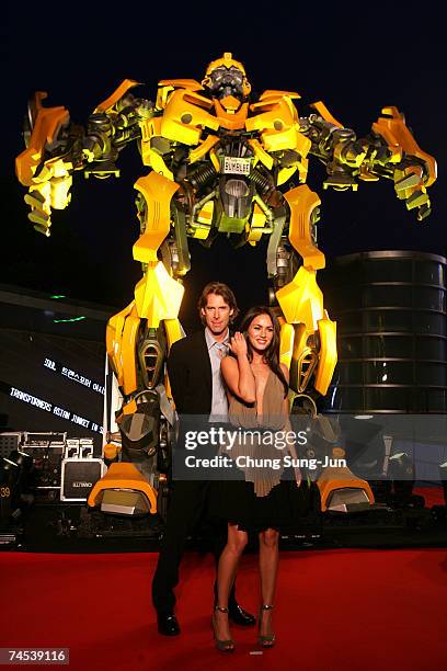 Film director Michael Bay and actress Megan Fox attend in front of Bumble Bee before a press conference to promote their new film "Transformers" on...