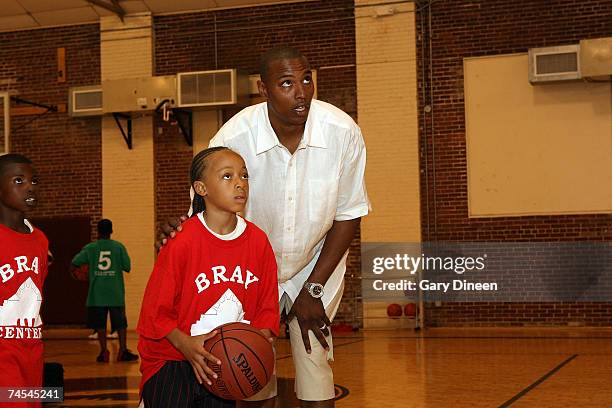 Caron Butler of the Washington Wizards teaches basketball shooting skills to children during the Caron Butler 3D Youth Basketball Camp on June 11,...