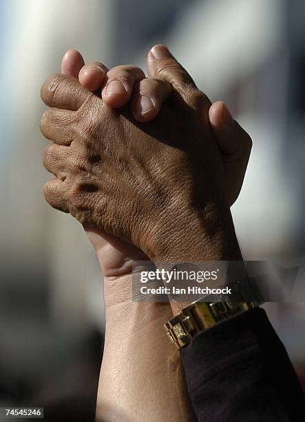 Aboriginal and Caucasian hands are pictured together during prayers outside the Townsville Courthouse June 12, 2007 in Townsville, Australia....