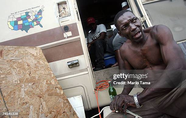 Palazzola Simmons attempts to hook up a wire for a generator in the doorway of the old motor home he is currently living in with three other people...