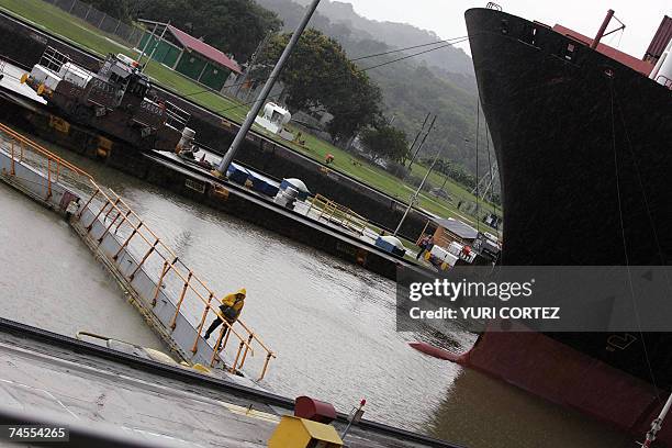 Un trabajador camina por un puente peatonal mientras el carguero Zin Beijing Monrovia espera en las Esclusas de Miraflores para cruzar el Canal de...