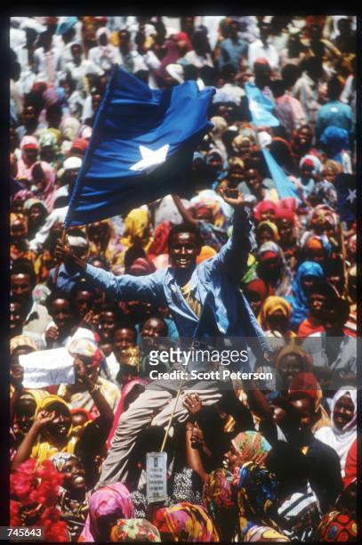 Man is lifted above the crowd at a rally for General Mohammad Farrah Aidid October 14, 1993 in Mogadishu, Somalia. A powerful warlord, Aidid...