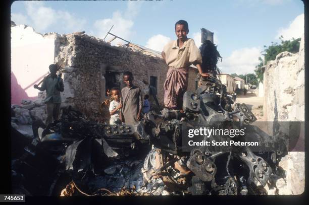 Children stand atop the wreckage of an American helicopter October 14, 1993 in Mogadishu, Somalia. This Blackhawk helicopter, which was used to root...