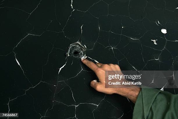 Man points to a bullet hole in a wall of the burnt-out remains of the house where Jamal Abu al-Jadian, senior leader of Al-Aqsa Martyrs Brigades was...