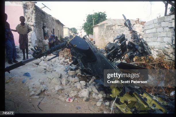 Children stand among the wreckage of an American helicopter October 14, 1993 in Mogadishu, Somalia. This Blackhawk helicopter, which was used to root...