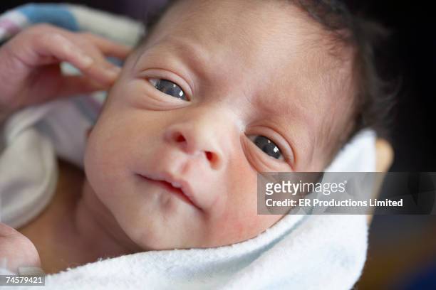 close up of newborn african baby in blanket - examining newborn stock pictures, royalty-free photos & images