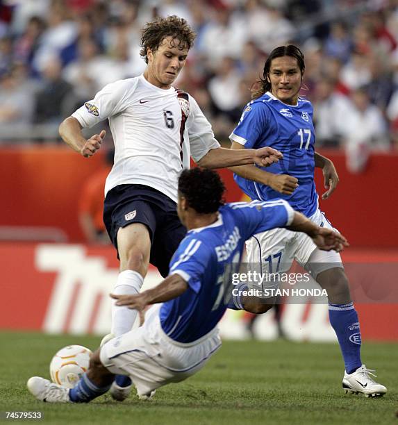 Foxboro, UNITED STATES: Alexander Escobar of El Salvador slides to kick the ball from Michael Bradley of the USA as Dennis Alas of El Salvador...