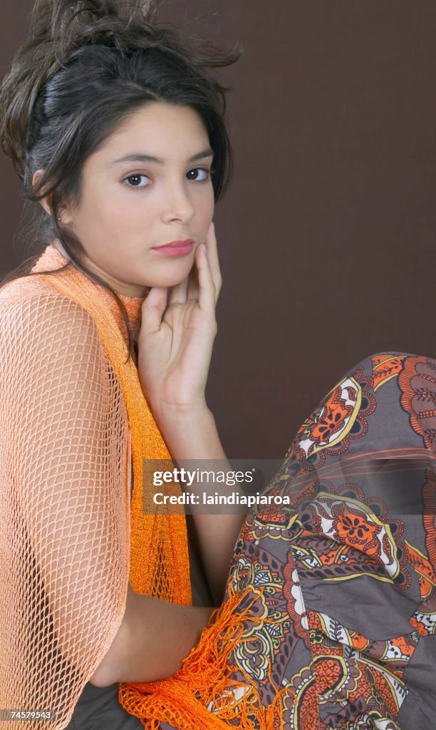 Hispanic girl with hand on face