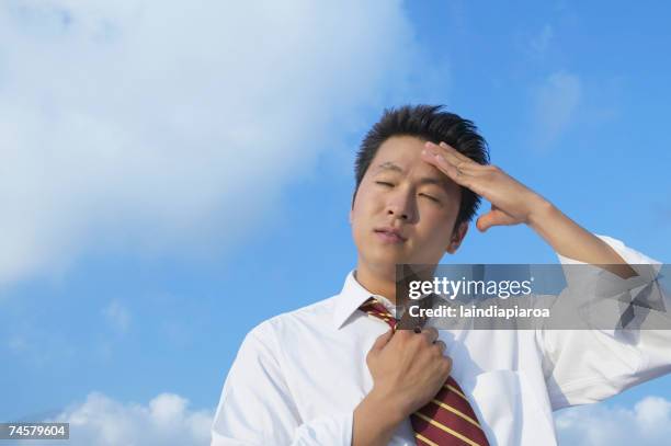 Asian Businessman Rubbing Forehead, Foto de stock