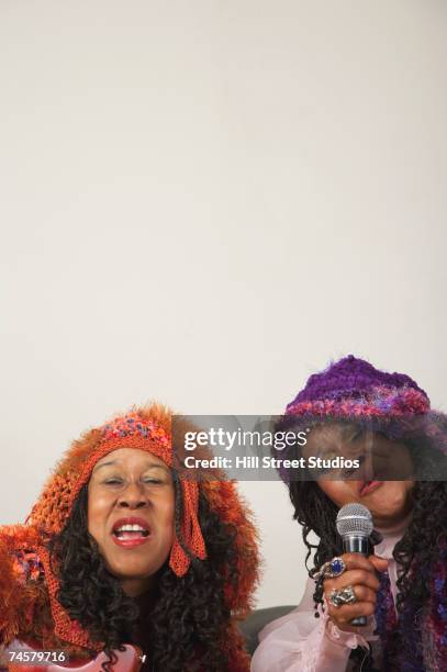 two senior african women singing - eccentric stock pictures, royalty-free photos & images