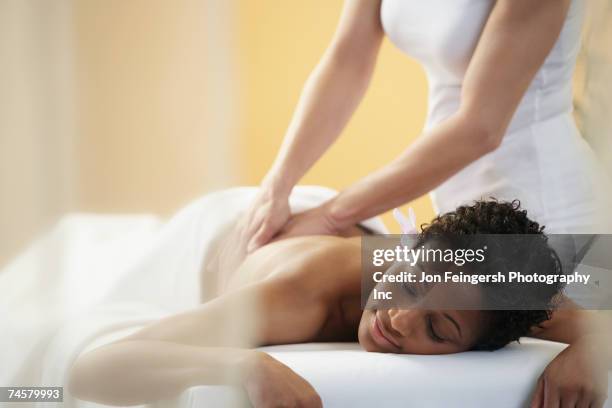 african woman receiving massage - women massage stock-fotos und bilder