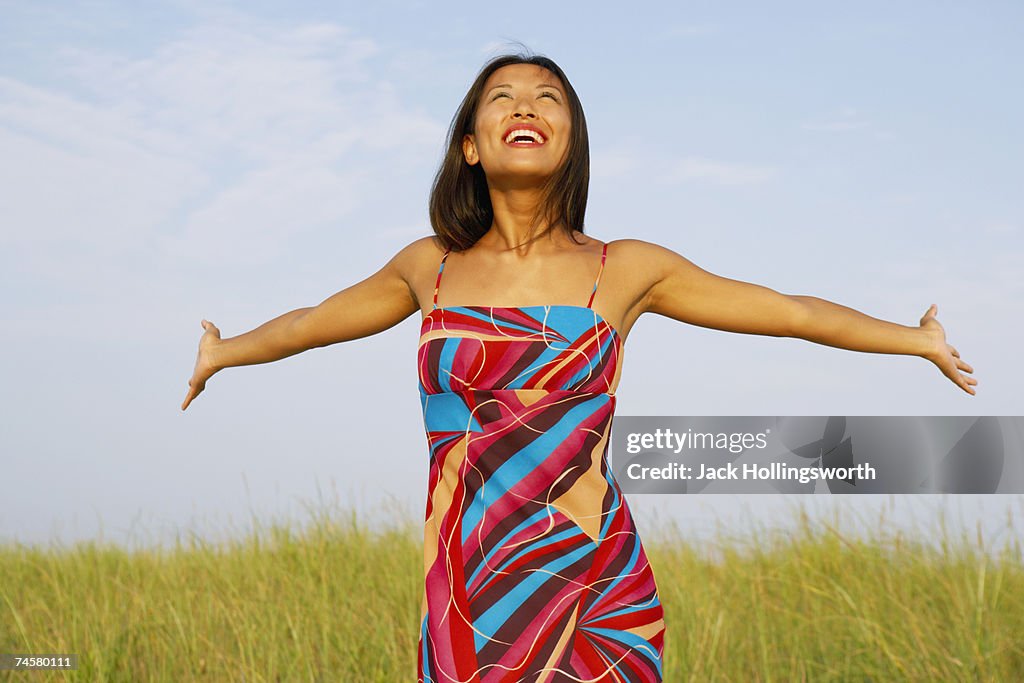 Asian woman with arms outstretched