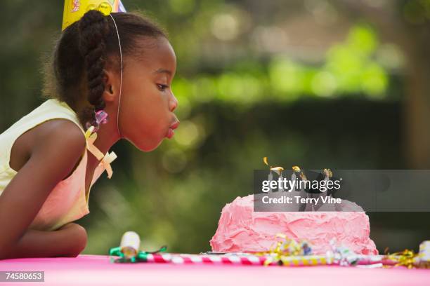 african girl blowing out candles at birthday party - young black girl profile stock-fotos und bilder