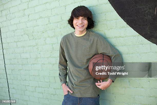 hispanic boy holding basketball - only teenage boys stock pictures, royalty-free photos & images