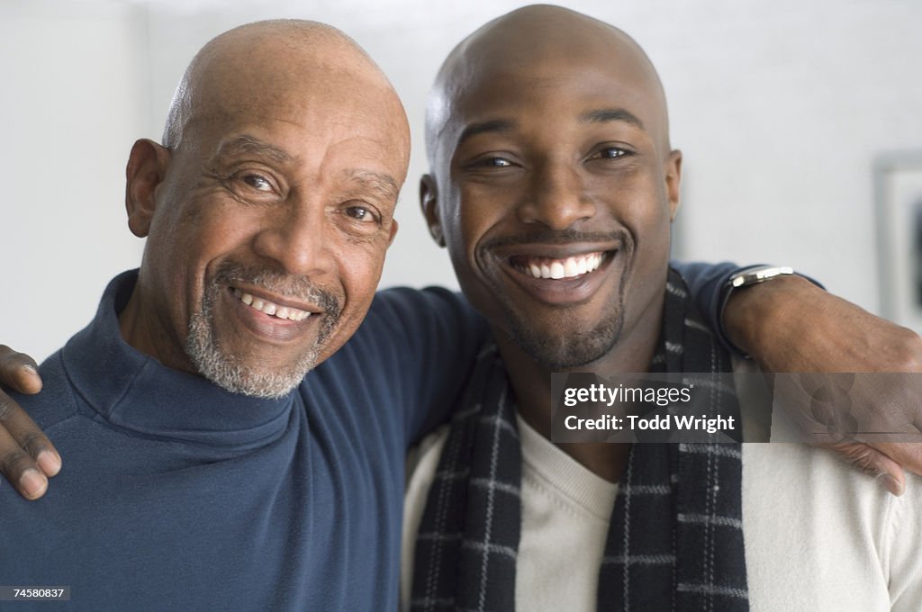 African father and adult son hugging