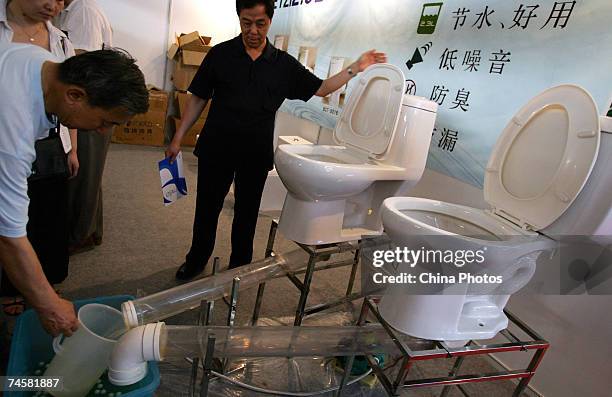 Man collects water from a saving-water toilet to test if per flush of it just use about 2 liters of water , at the Beijing International...