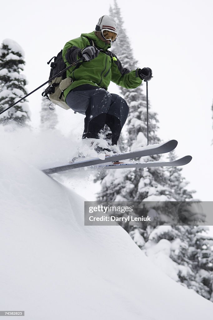 Backcountry skier jumping, low angle view
