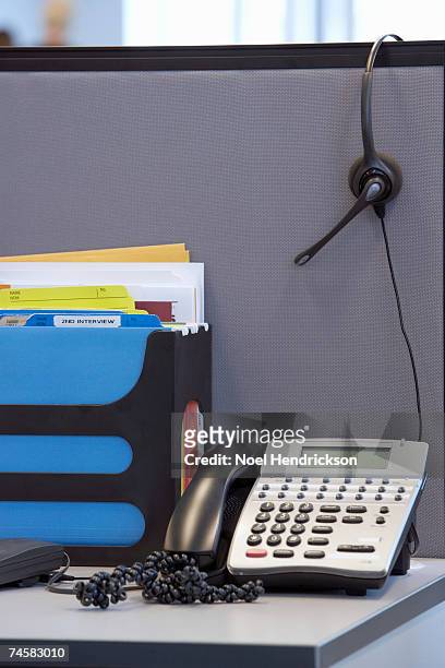 desk in cubicle with phone and file rack, headset hanging on wall - hanging file stock pictures, royalty-free photos & images