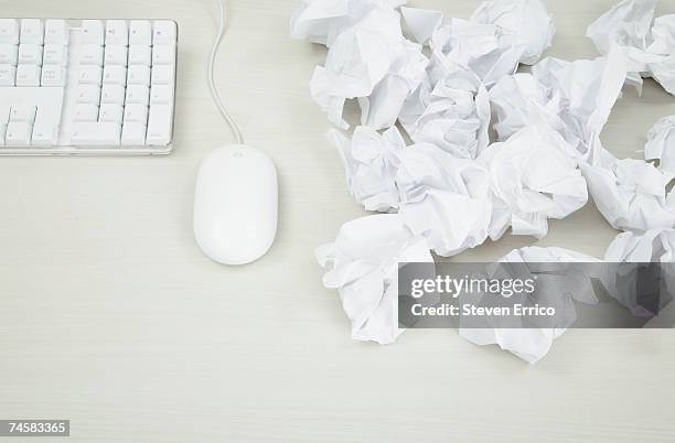 crumpled paper balls next to computer mouse and keyboard, close-up, elevated view - papierkugel stock-fotos und bilder