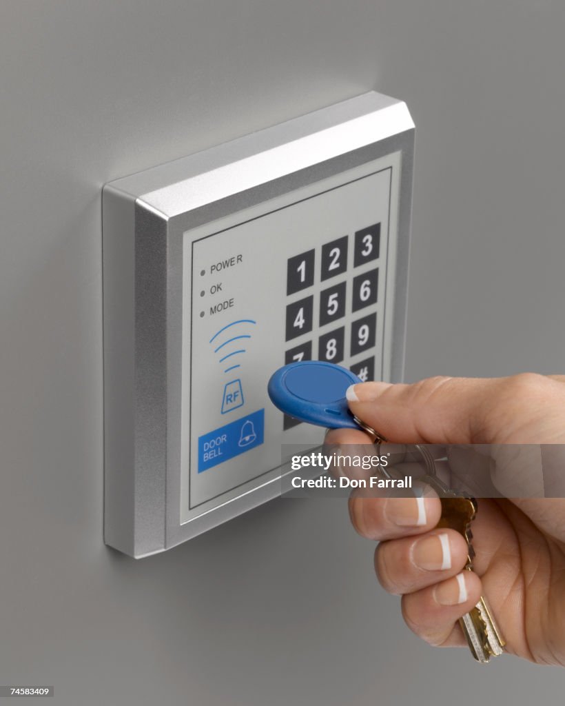 Hand holding key fob up to RFID pad