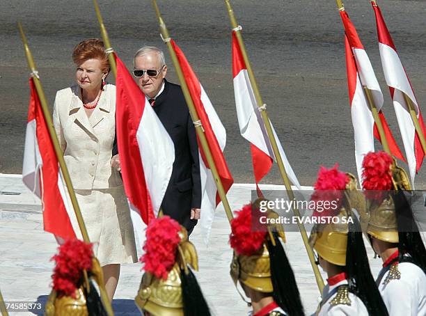 Latvia's President Vaira Vike-Freiberga and her husband Imants Freibers review an honour guard during a welcoming ceremony at the Planalto Palace, 13...